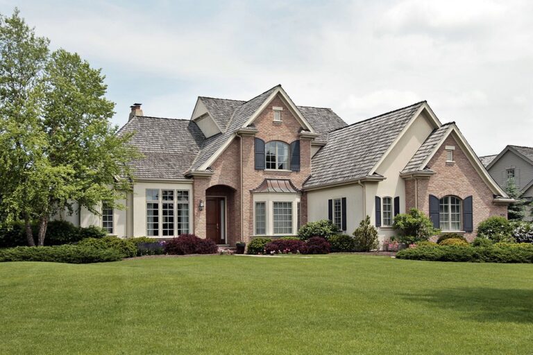 a photo of a brown house with a spacious frontyard
