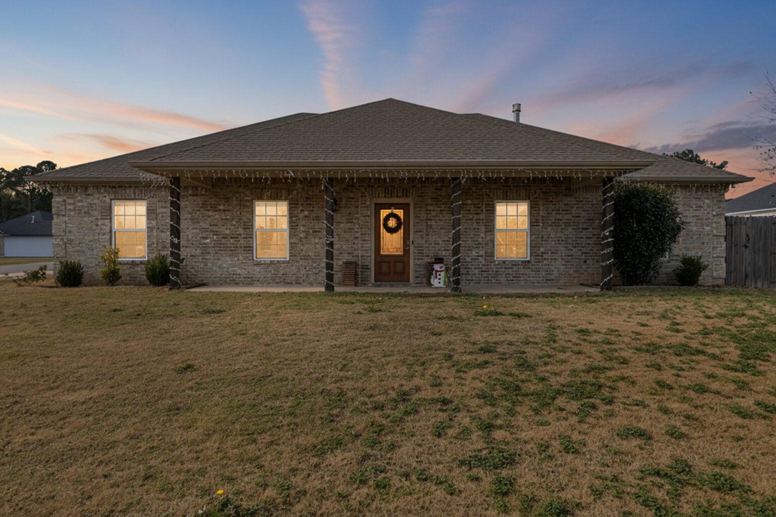 single-story brick home with a covered front porch with decorative columns