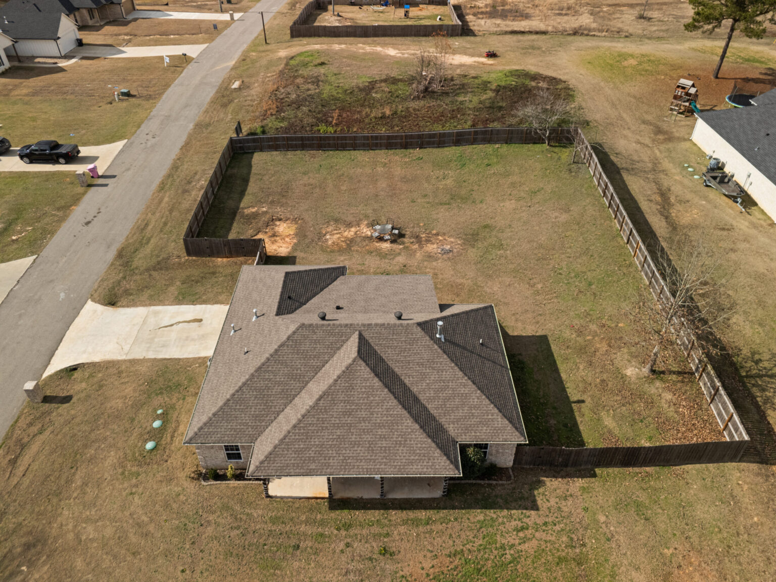 an aerial view of a single-family home extended back patio and a concrete pad