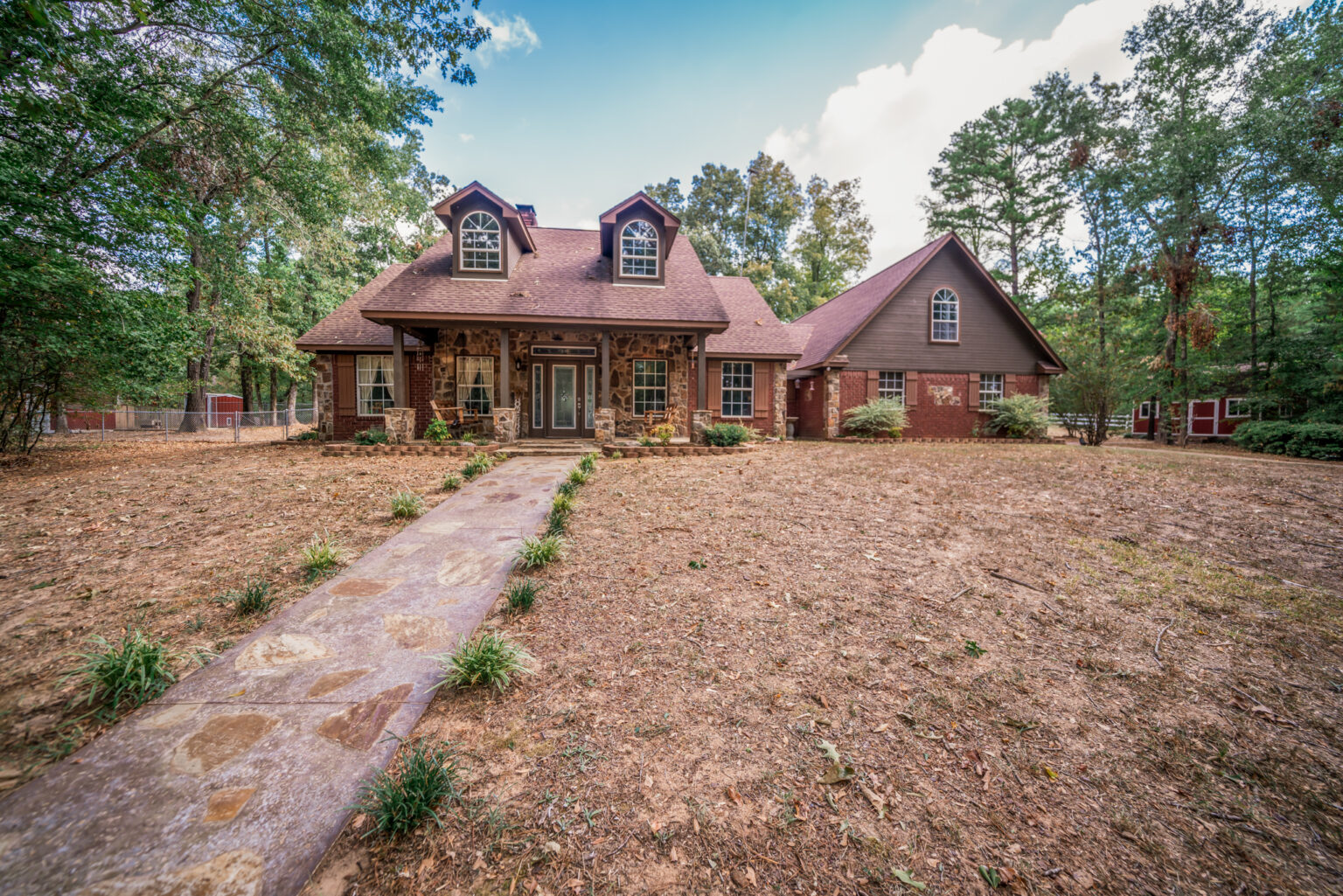 a house features a mix of red brick and stone veneer on the exterior
