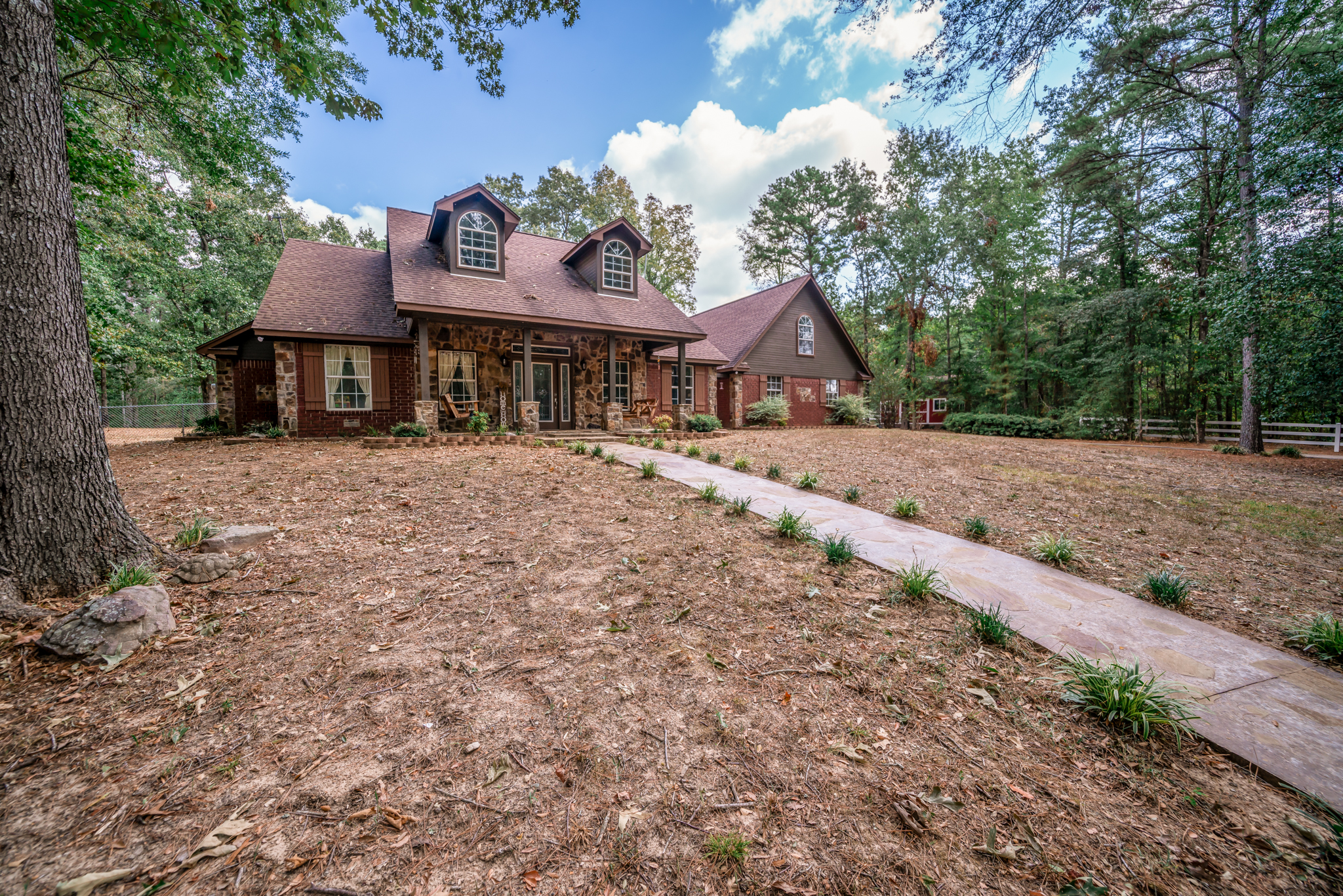 a house features a mix of red brick and stone veneer on the exterior
