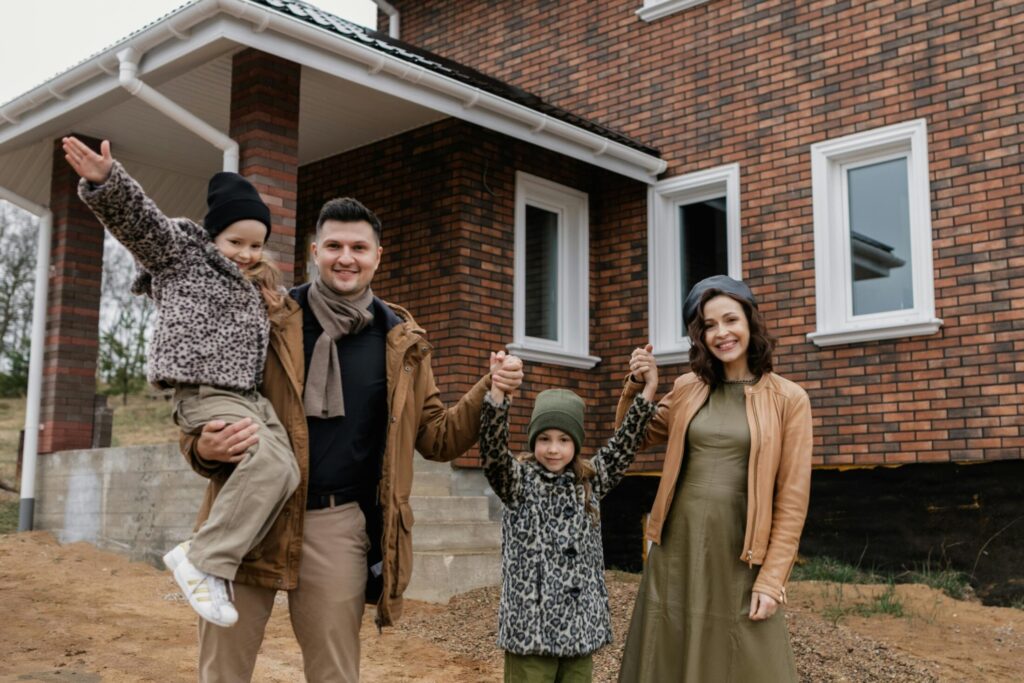 a family standing in front of their new house