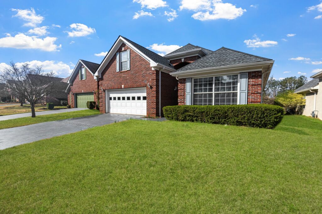 Charming red brick suburban home in daylight.