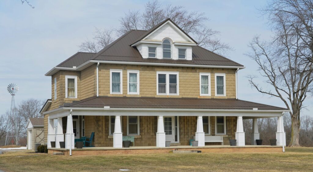 a large brown house sitting in the middle of a field