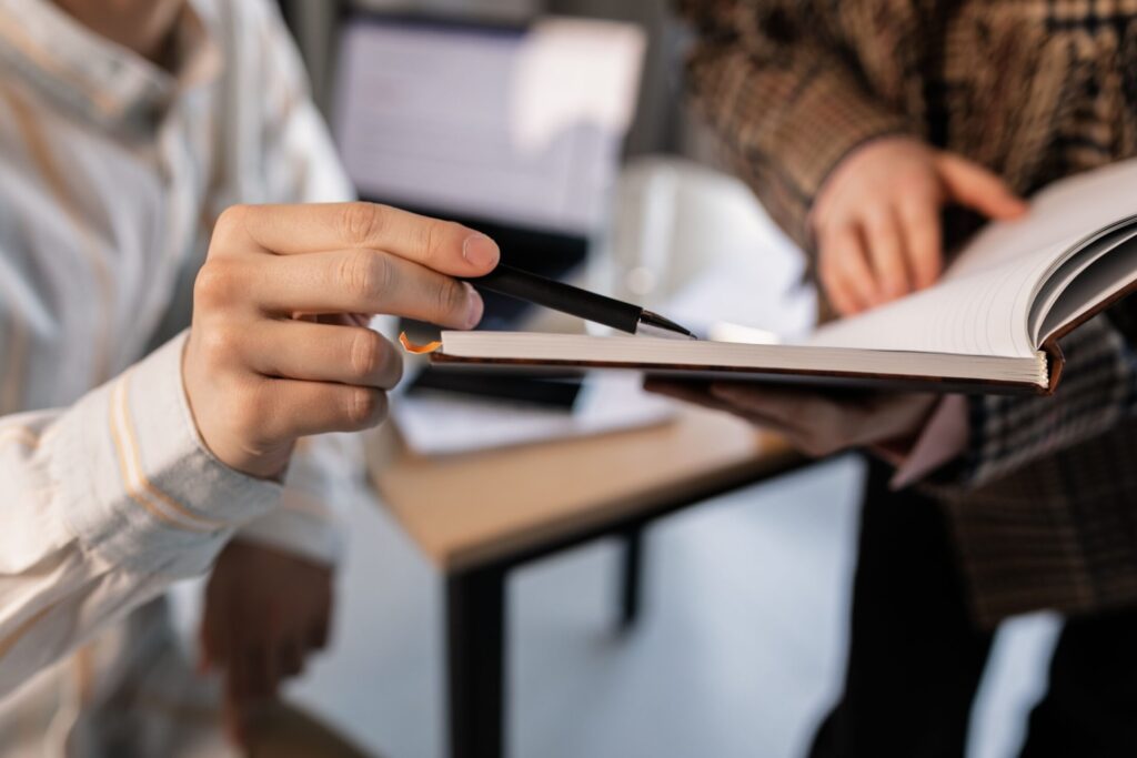 A close-up view of two colleagues collaborating at a desk