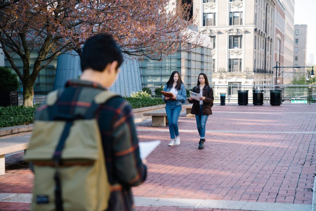 An outdoor shot on a brick-paved university courtyard featuring students walking
